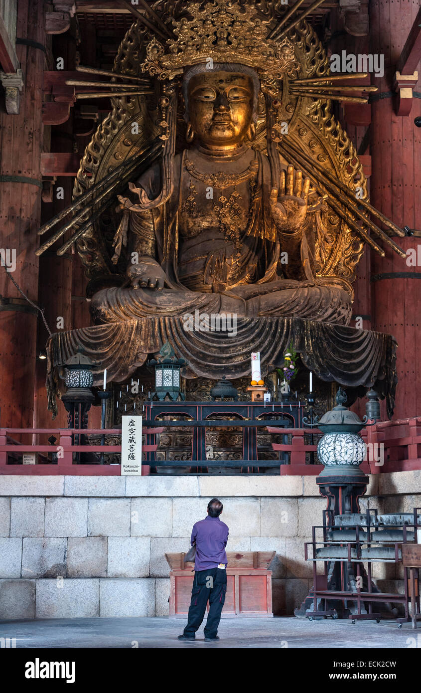 Im Todai-JI-Tempel (Nara, Japan) steht ein Mann unter einer riesigen Statue von Kokuzo Bosatsu, einem Bodhisattva aus dem 9. Jahrhundert, der den Shingon-Buddhismus gründete Stockfoto