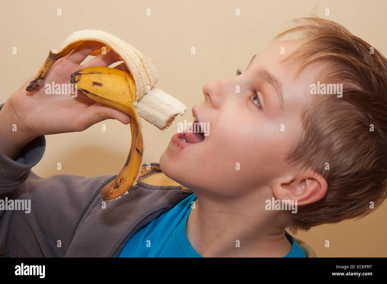 Ein blondes Haar junge eine Banane essen Stockfoto