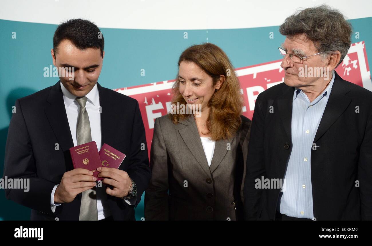 Musa Cakilli (L-R), hält seine deutschen und türkischen Pässe in seinen Händen, da er neben der deutschen Bundesregierung Kommissar für Integration, Aydan Oezoguz (SPD) und Ethnologe und Kulturwissenschaftlerin, Werner Schiffauer, während einer Pressekonferenz für die Kampagne "Ein Leben, Zwei Paesse" (ein Leben, zwei Pässe) in Berlin, Deutschland, 16. Dezember 2014 steht. Ziel der Kampagne ist es, junge Menschen mit Migrationshintergrund über die Änderungen in Bezug auf die deutsche Nationalität Gesetzes, am 20. Dezember 2014 in Kraft zu informieren. Foto: Britta Pedersen/dpa Stockfoto