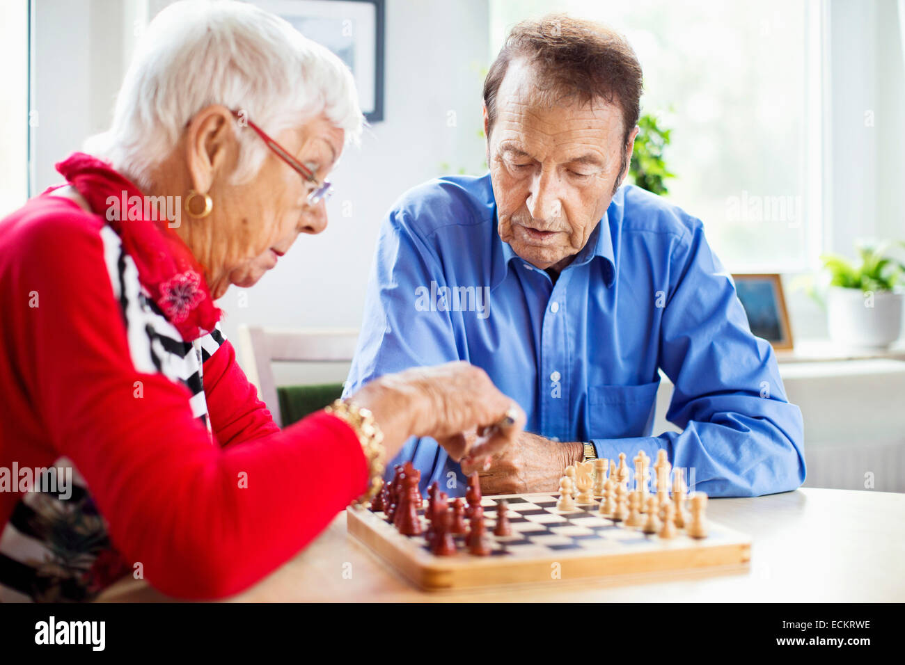 Älteres Paar beim Schachspiel am Tisch im Pflegeheim Stockfoto