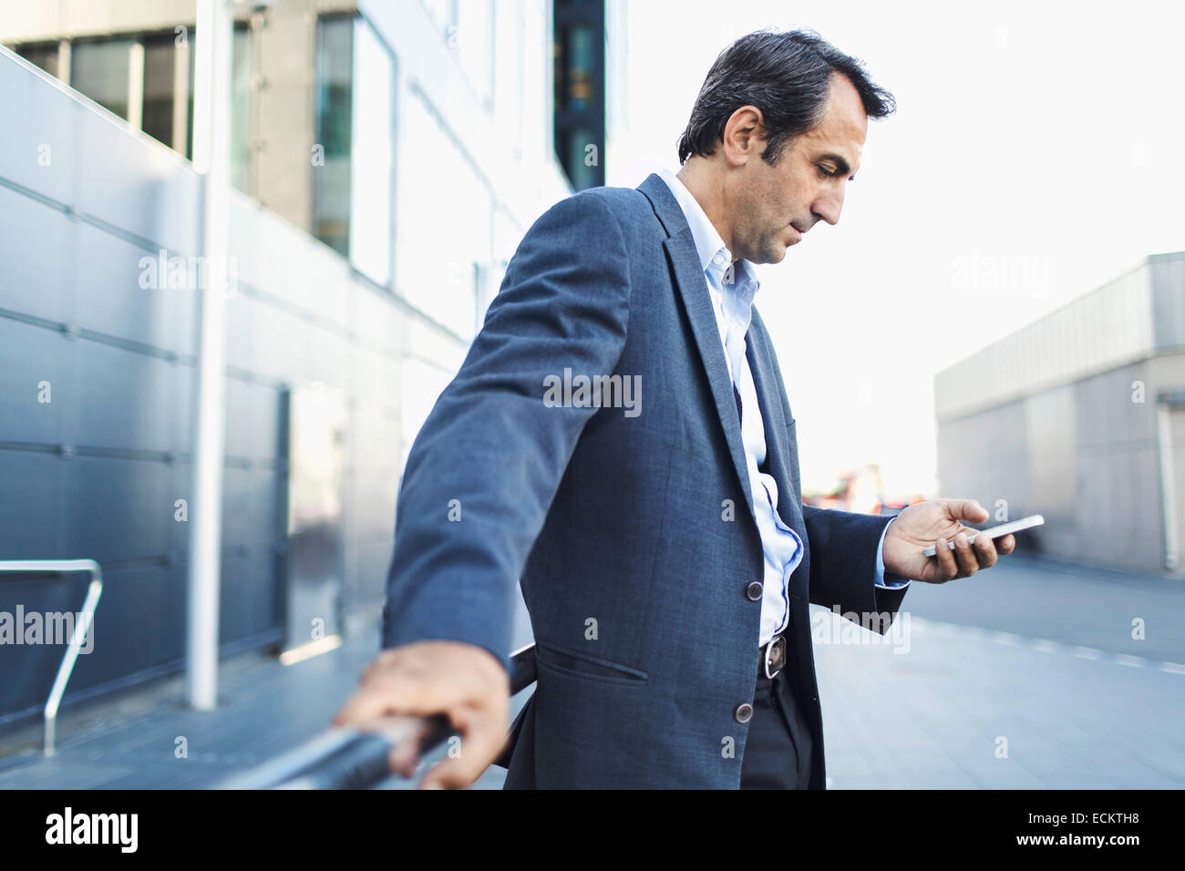Geschäftsmann mit Handy auf Bürgersteig Stockfoto
