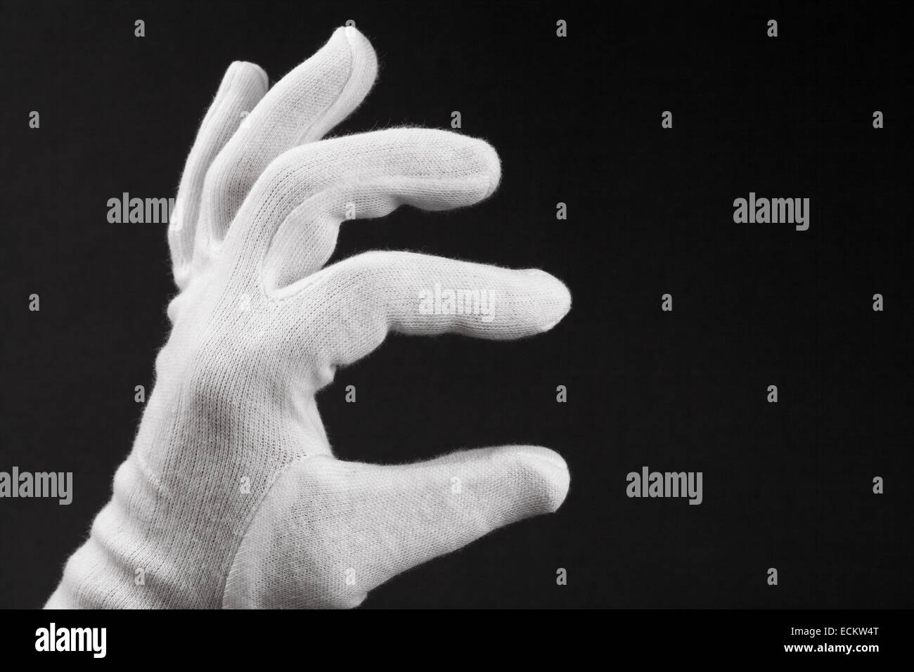 Menschliche Hand in weißen Handschuhen, auf schwarzem Hintergrund isoliert. Stockfoto