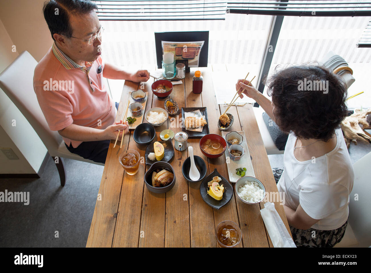 Frau und Mann sitzt an einem Tisch, japanisches Essen mit Stäbchen zu essen. Stockfoto