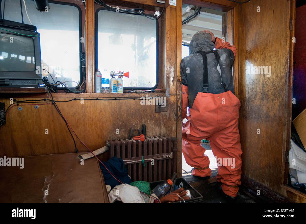 Kapitän der Fischerei Dragger blickt auf Deck als Net ist zurück gezogen. Stockfoto