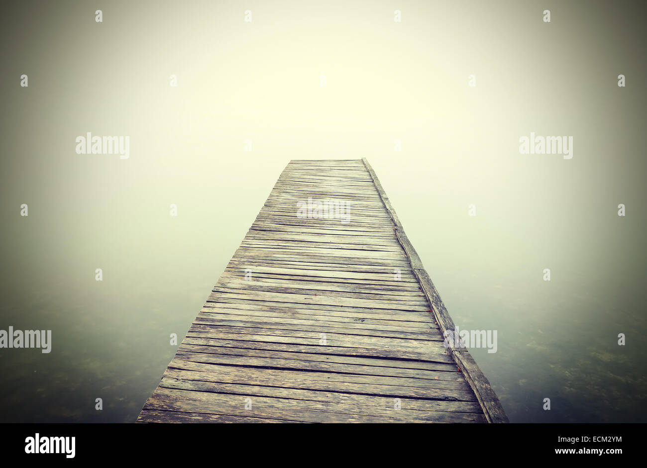 Retro-gefilterte Bild der alten hölzernen Pier in dichtem Nebel. Stockfoto