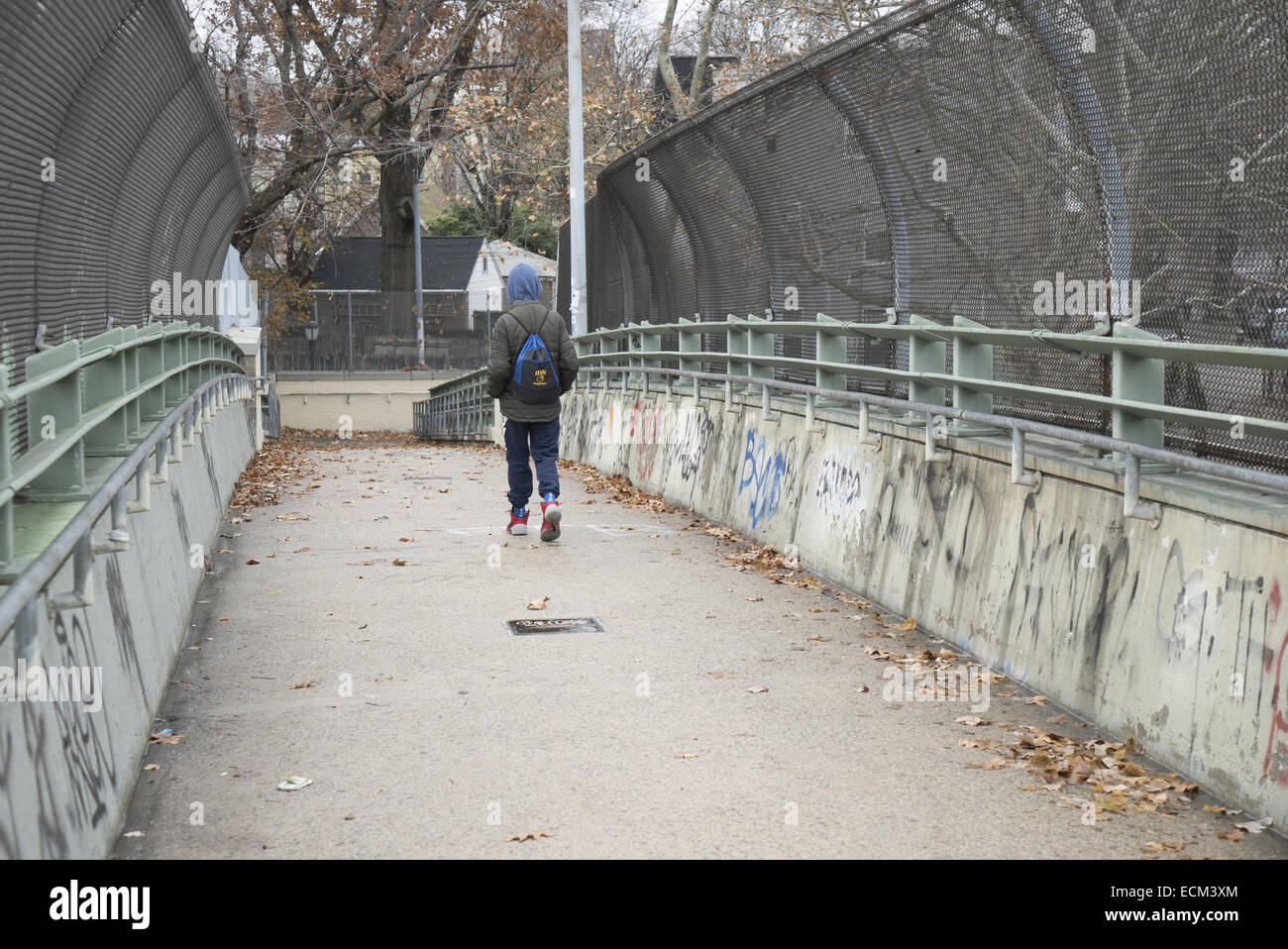 Teen Junge geht nach Hause über eine Fußgängerbrücke im Stadtteil Windsor Terrace, Brooklyn, NY. Stockfoto