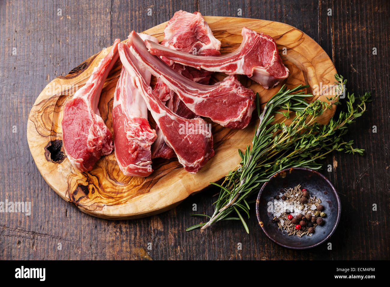 Rohes frisches Lammfleisch Rippen und Gewürze auf dunklem Holz Stockfoto