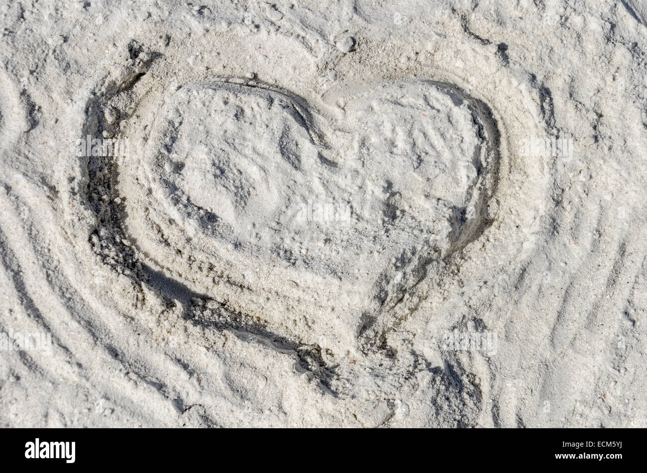 Das Symbol des Herzens ist auf Sand gezeichnet. Stockfoto