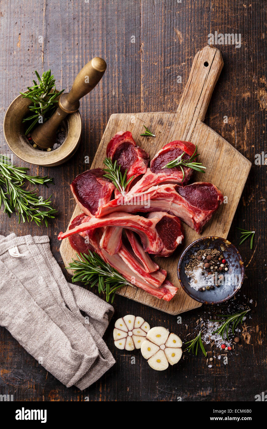 Rohes frisches Lammfleisch Rippen und Gewürze auf dunklem Holz Stockfoto