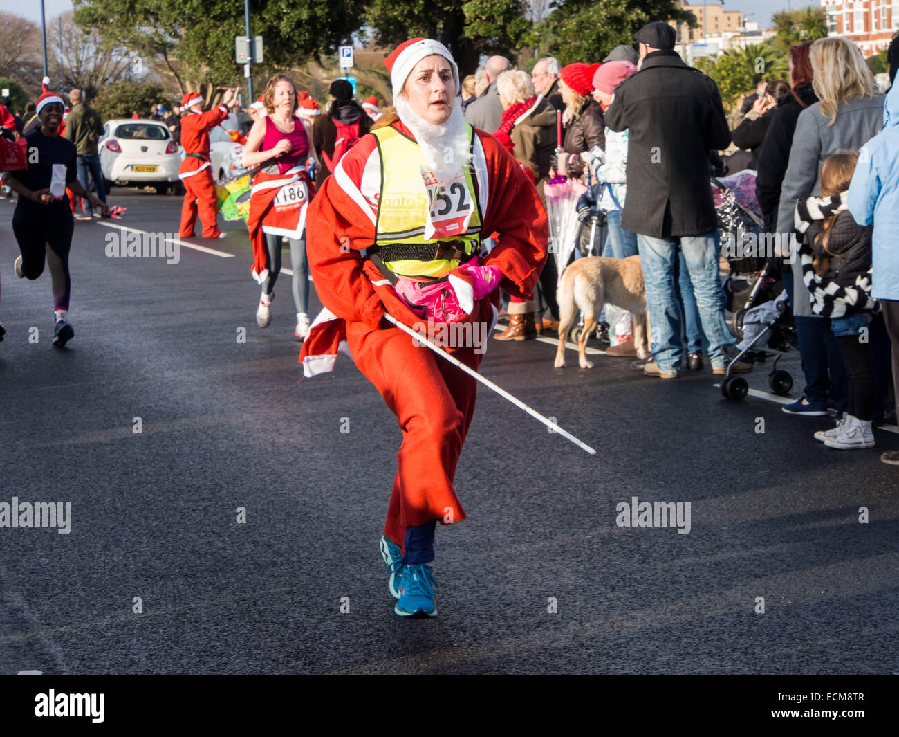 Ein sehbehinderter Läufer verkleidet als Weihnachtsmann Santa-Volkslauf in Portsmouth, England teilnimmt Stockfoto