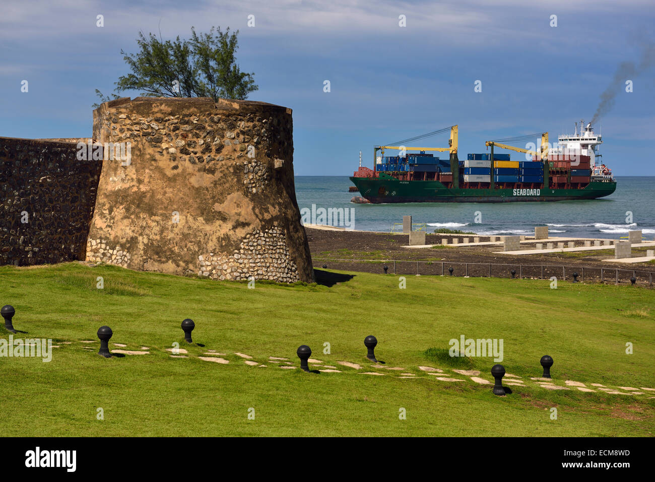 Containerschiff in Puerto Plata Bucht und Hafen mit Wänden aus San Felipe Festung Dominikanische Republik Stockfoto