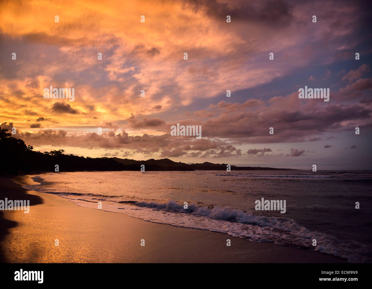 Goldenen Wolken bei Sonnenuntergang reflektiert nass Strandsand Maimon Bay Riu Strandresort Dominikanische Republik Stockfoto