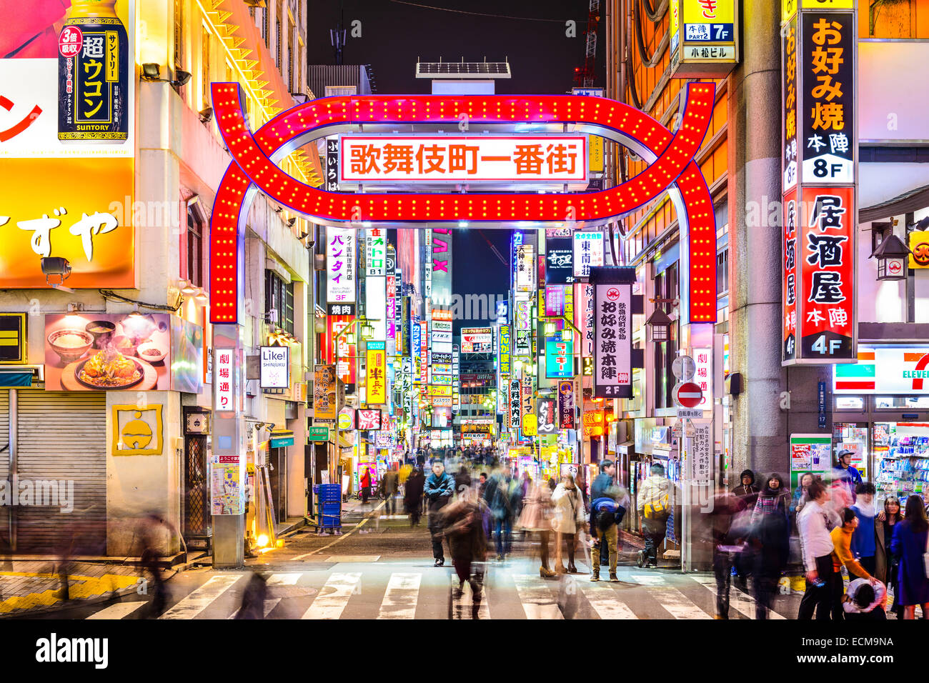 Fußgänger gehen unten Zeichen dicht entlang einer Gasse in Kabuki-Cho, Tokio, Japan. Stockfoto