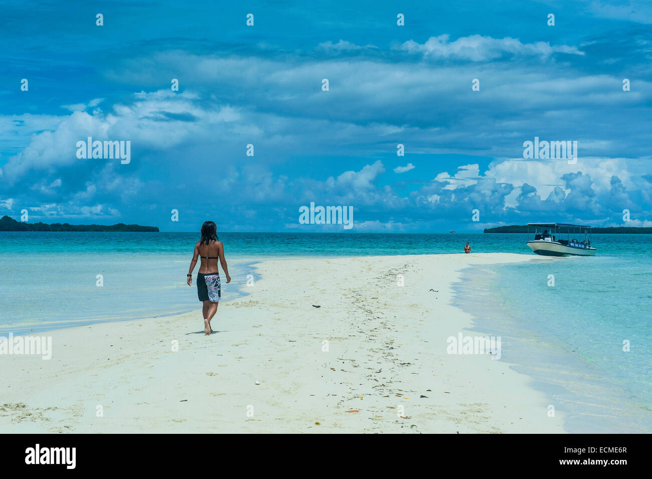 Touristen, die zu Fuß auf einen Sandstreifen bei Ebbe, Rock Islands, Palau Stockfoto