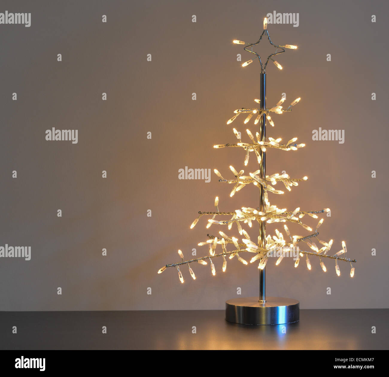 stilisierten silbernen Metall und Draht Weihnachtsbaum mit weißen Lichtern, neutralen Hintergrund und linken Textfreiraum Stockfoto