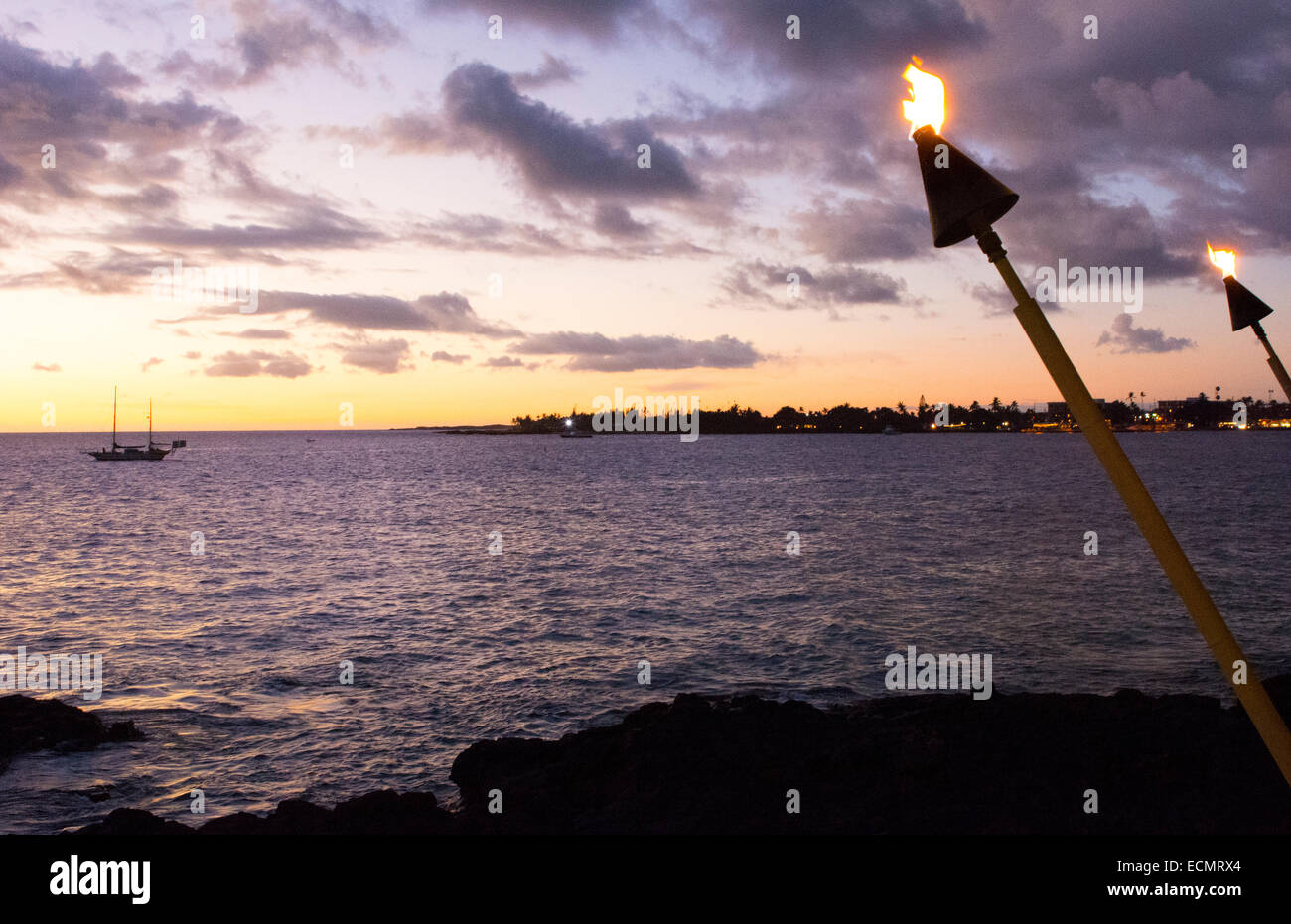 Kona Hawaii Big Island Tiki Feuer Licht über Meer in Kailua-Kona Beach bei Sonnenuntergang friedliche Entspannung Stockfoto