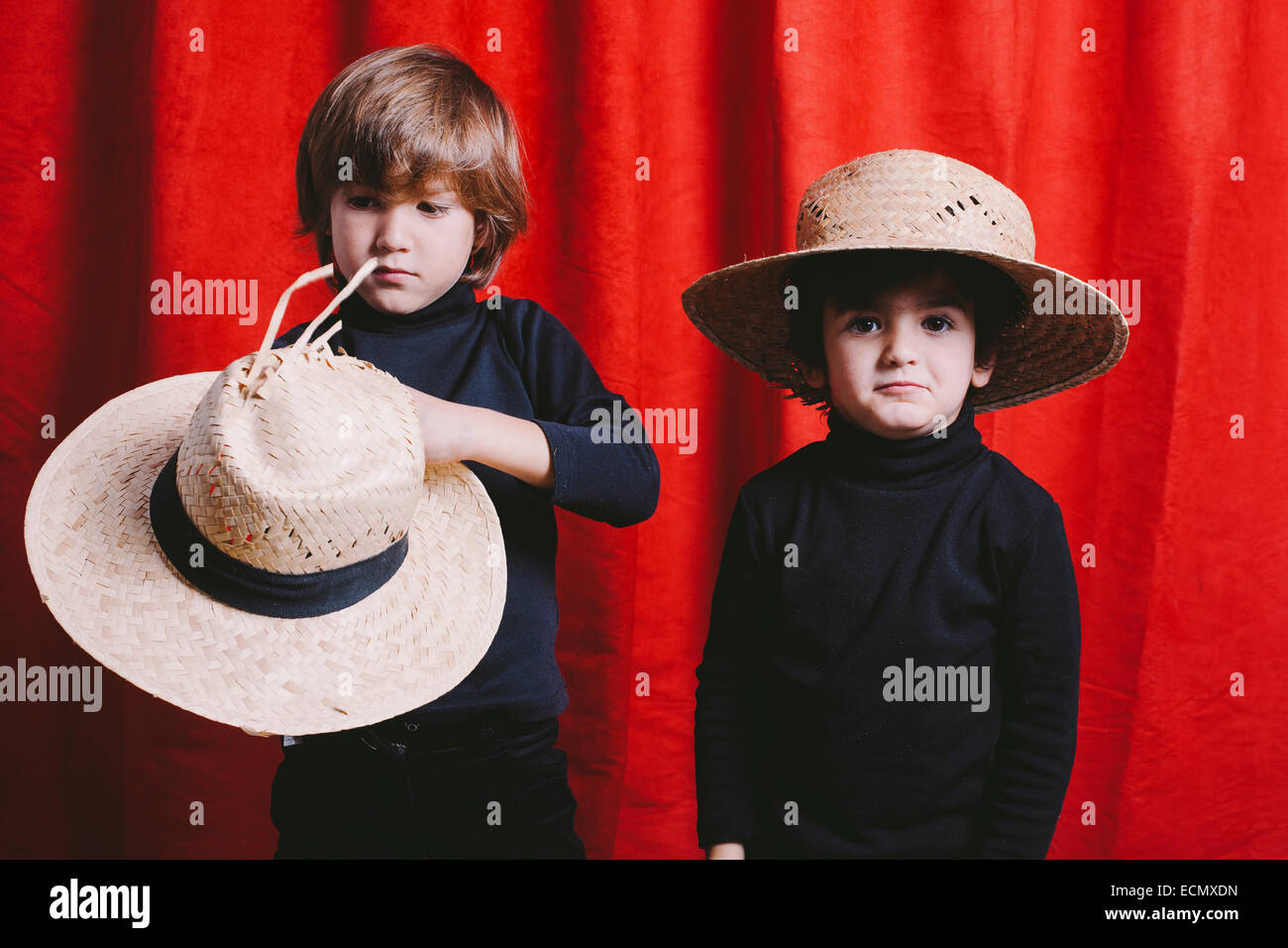 Studio-Porträt von zwei jungen tragen schwarze Kleidung und einen Strohhut Stockfoto