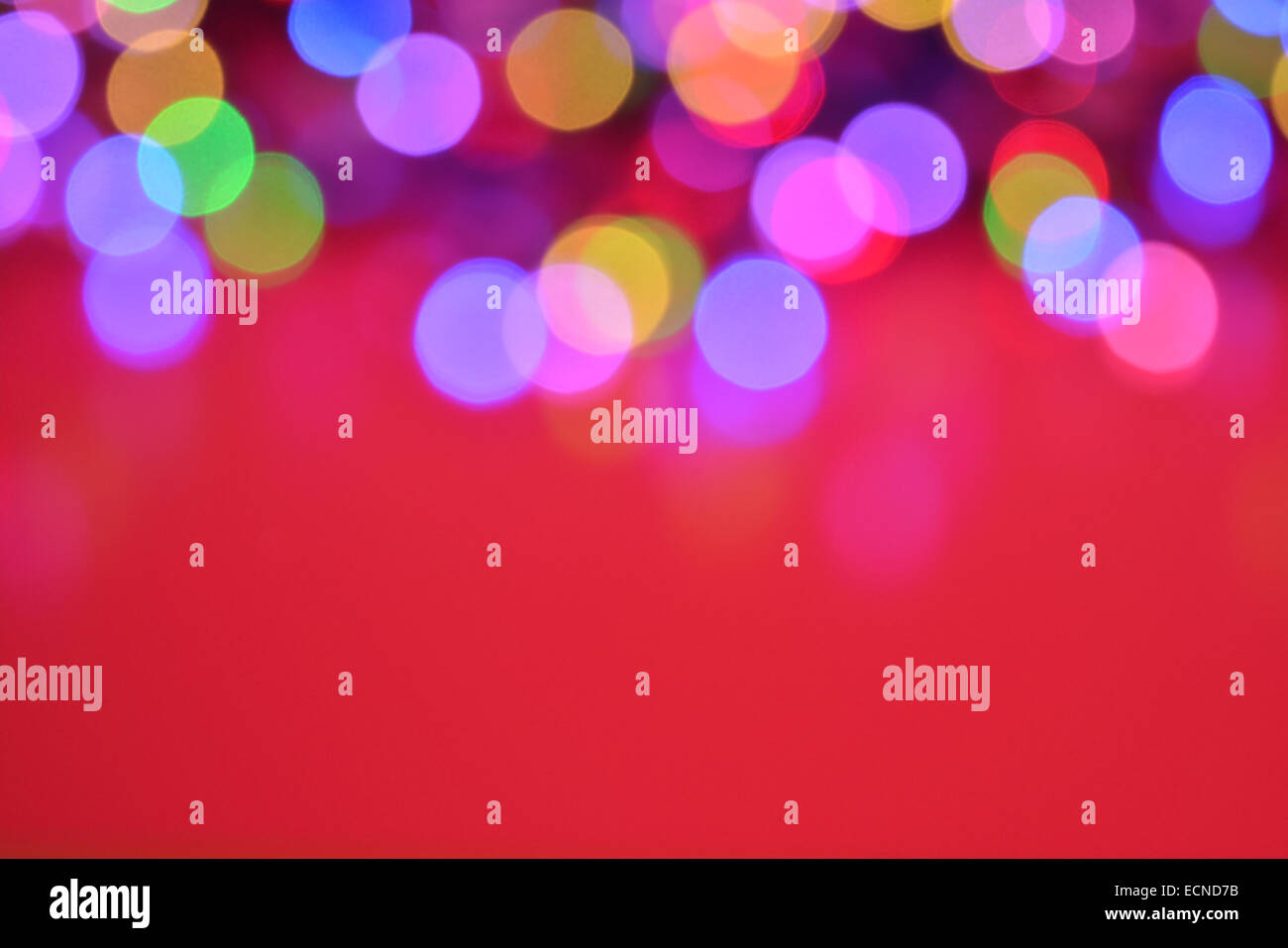 Hellen soft - Fokus mehrfarbigen pastellfarbenen Party Lichter vor rotem Hintergrund Stockfoto