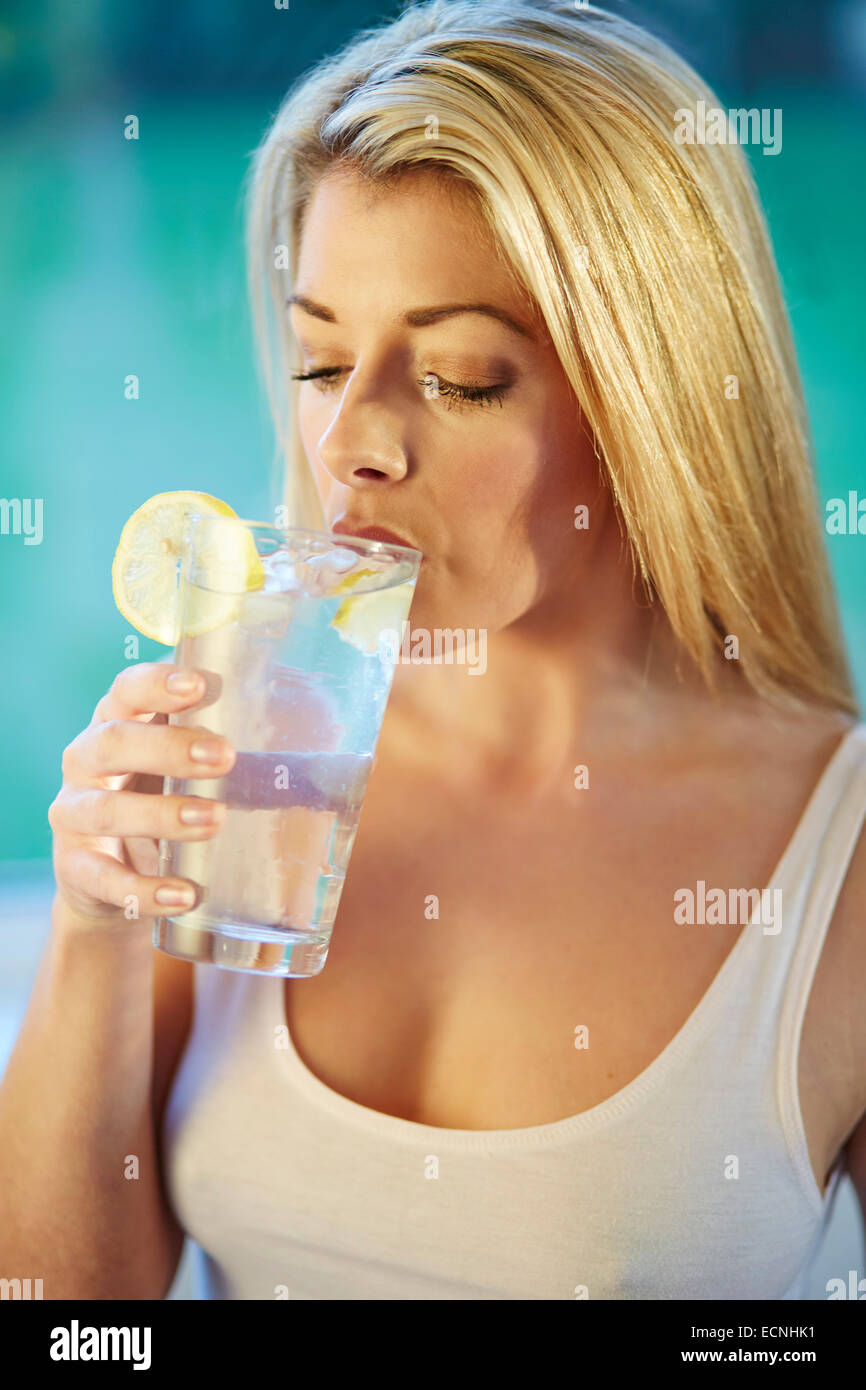 Mädchen trinken Glas Eiswasser mit Zitrone Stockfoto