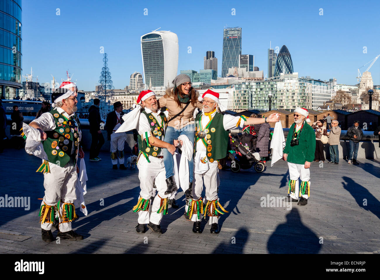 Eine weibliche italienische Touristen findet empor nach dem Tanzen mit der North Holz Morris Männer außen City Hall, London, England Stockfoto