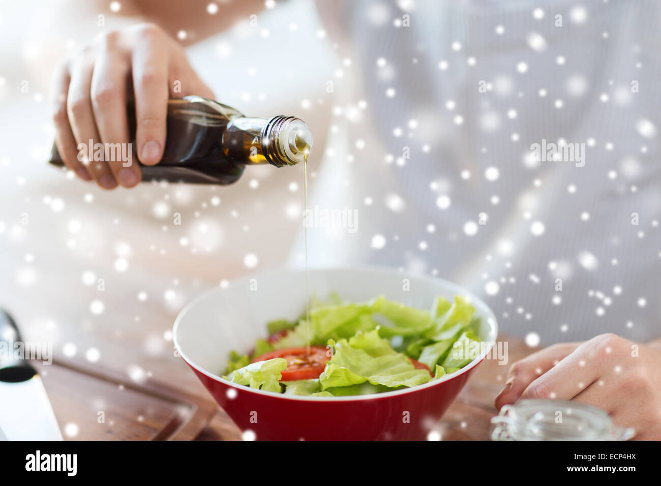 Nahaufnahme von Händen Aromastoffe Salat mit Olivenöl Stockfoto