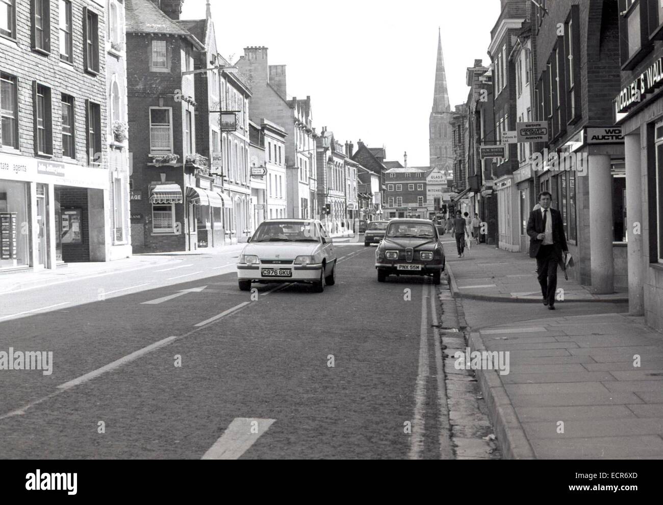 Verkehr auf Castle Street in Salisbury mit der Kathedrale im Jahr 1985 deutlich sichtbar. Eine neue Vauxhall Astra ist eine 1970er Jahren Saab außerhalb Woolley und Wallis Immobilienmakler übergeben. Stockfoto
