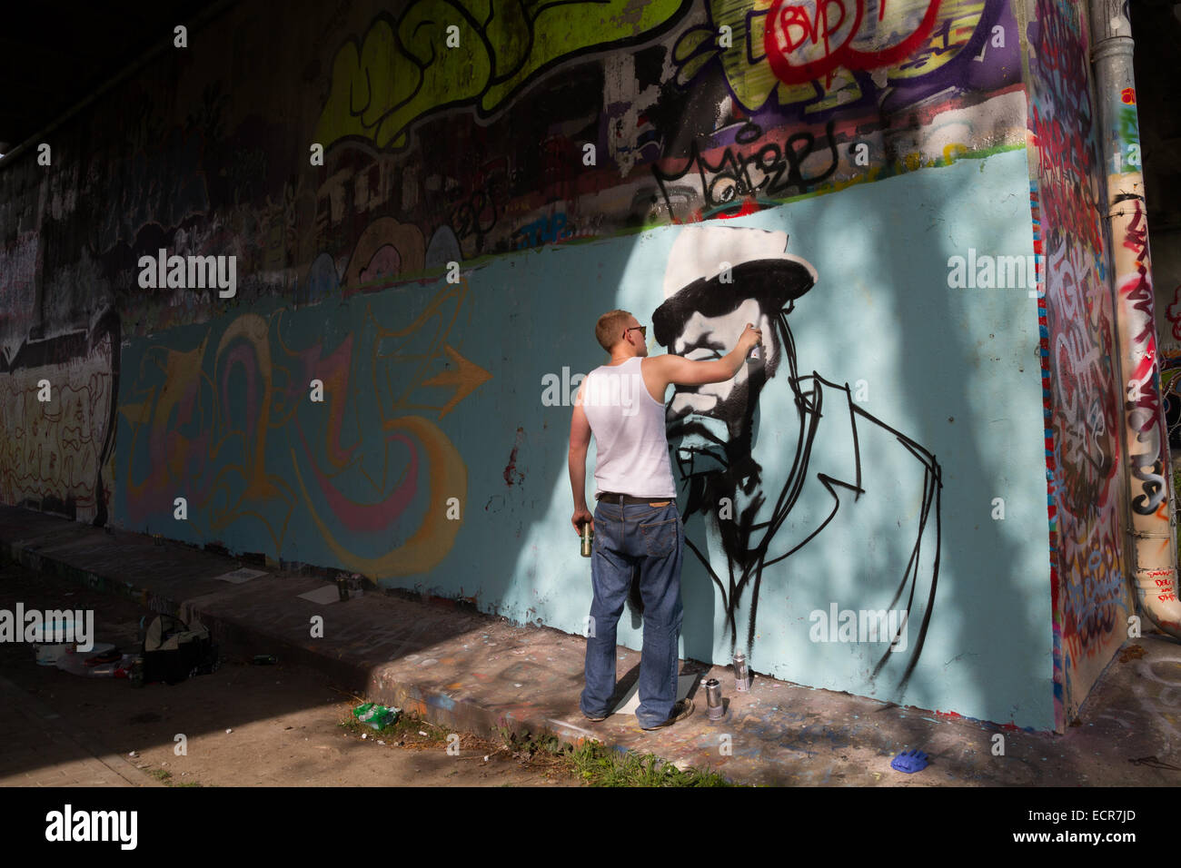 Ein Junge Graffiti-Künstler malen eine Wandbild unter einer Brücke in amsterdam Stockfoto
