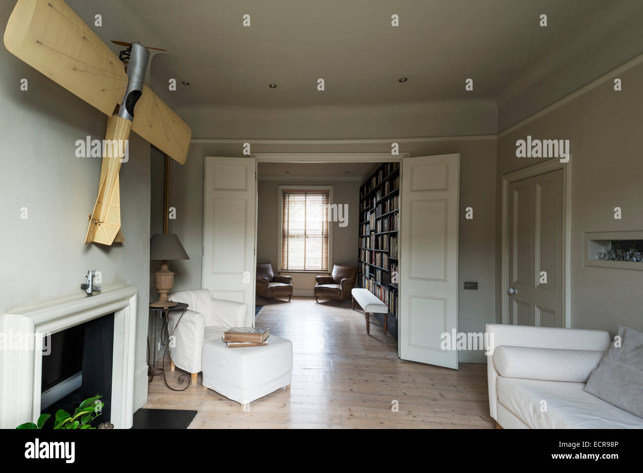 Groß angelegte Modellflugzeug hing über dem Kamin im großzügigen Wohnzimmer mit Doppel-Türen und weißen sofa Stockfoto