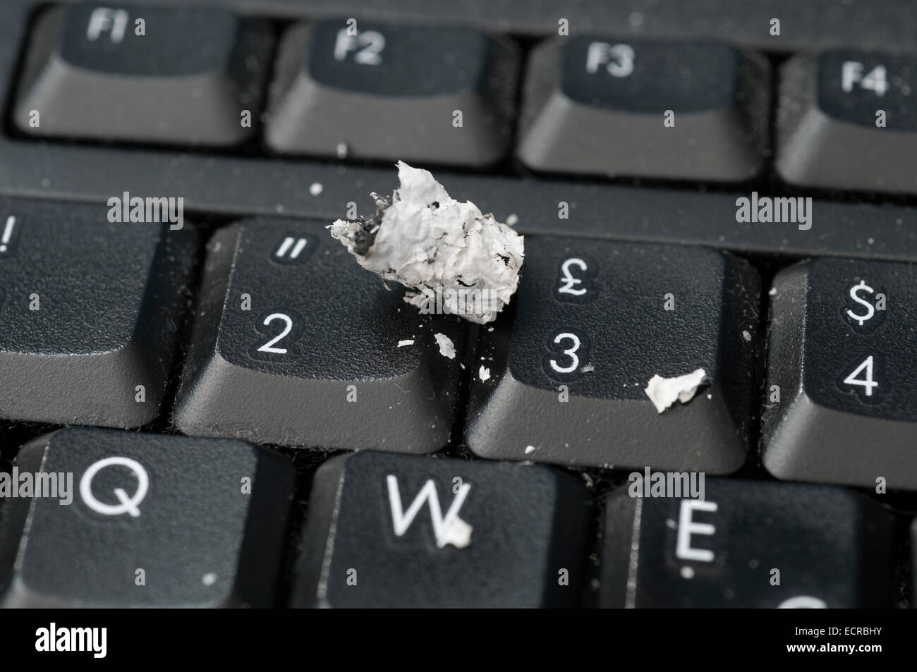 Zigarettenasche auf Computer-Tastatur gefallen Stockfoto