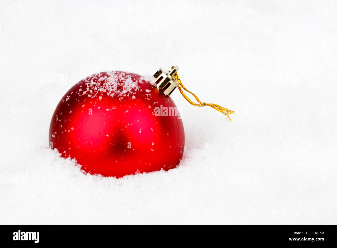 Rote Weihnachtskugel im Schnee Stockfoto