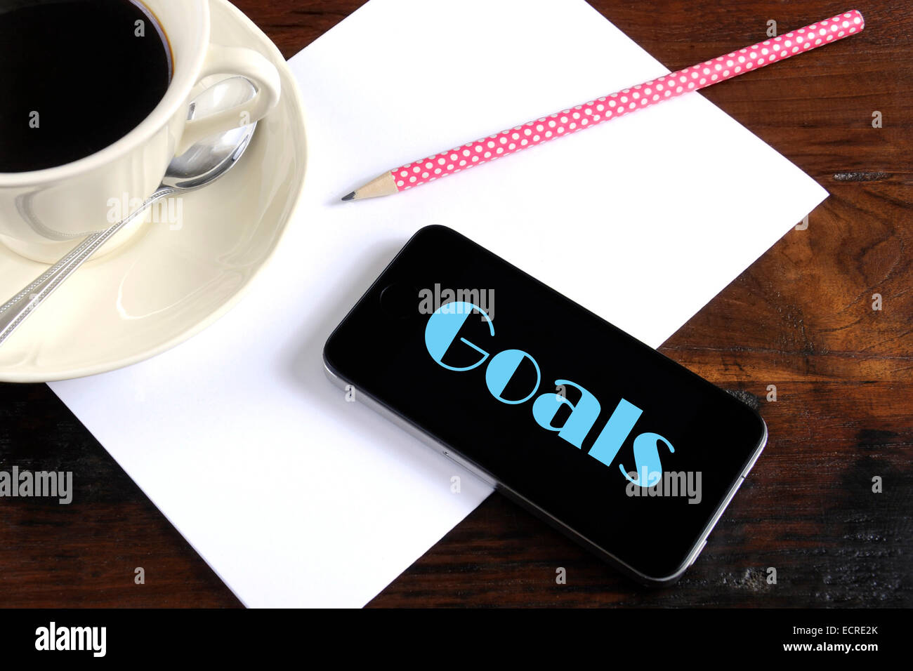 New Year Resolution oder Ziele Planung Konzept mit Smartphone-Gerät, Papier, Bleistift und Tasse Kaffee auf dunkel rustikalen Holztisch Stockfoto