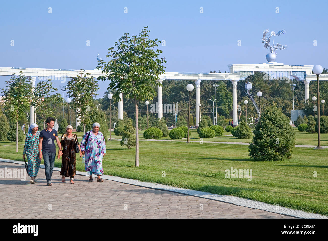 Usbekische Frauen in traditioneller Tracht, die zu Fuß durch Unabhängigkeitsplatz in Taschkent, Usbekistan Stockfoto