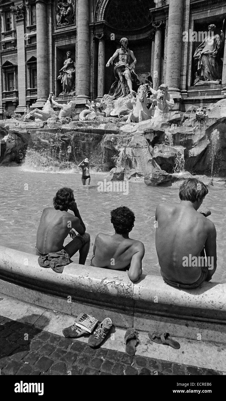 Rom, Italien - AUGUST 1980: drei Männer kühlen in den Trevi-Brunnen und schauen Sie sich eine junge Frau Baden im Springbrunnen am 19. August Stockfoto