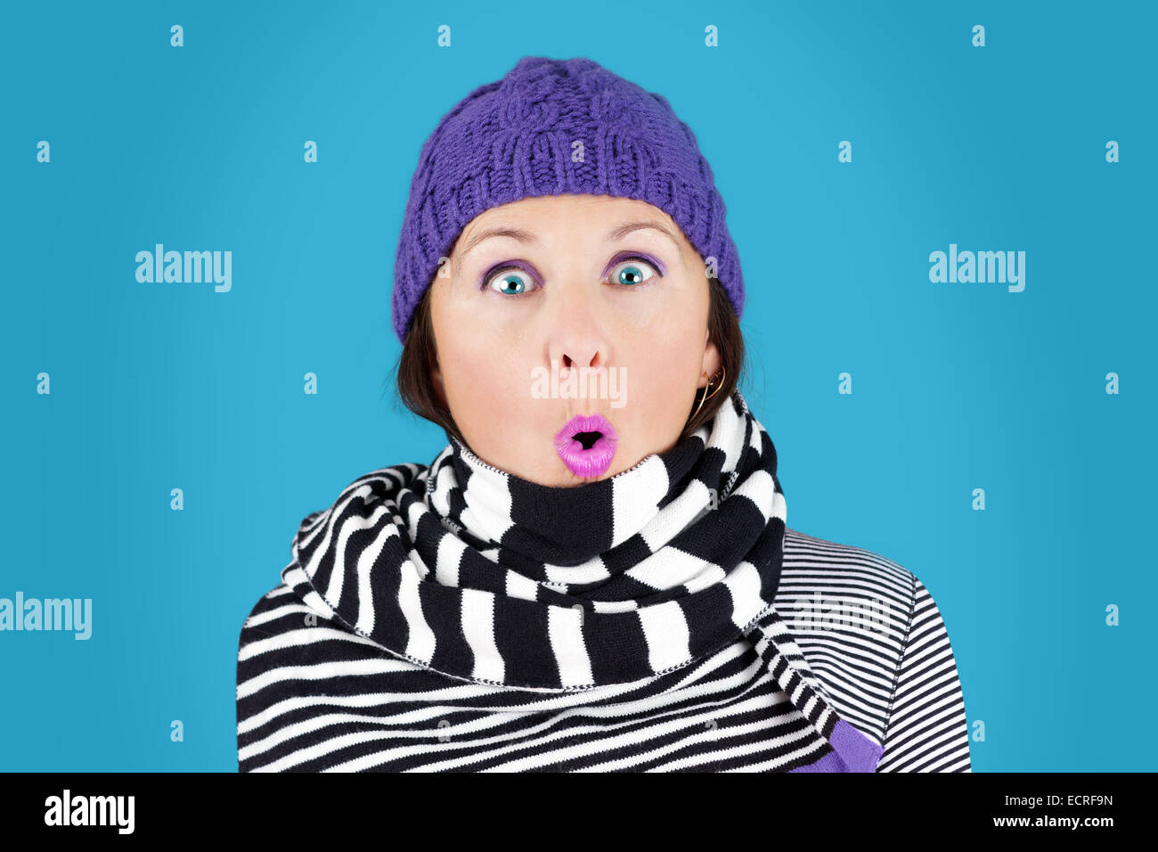 Lustig überrascht Gesicht Frau mit Hut und Streifen schwarz-weiß Wollschal: humorvolle Winter-Konzept Stockfoto
