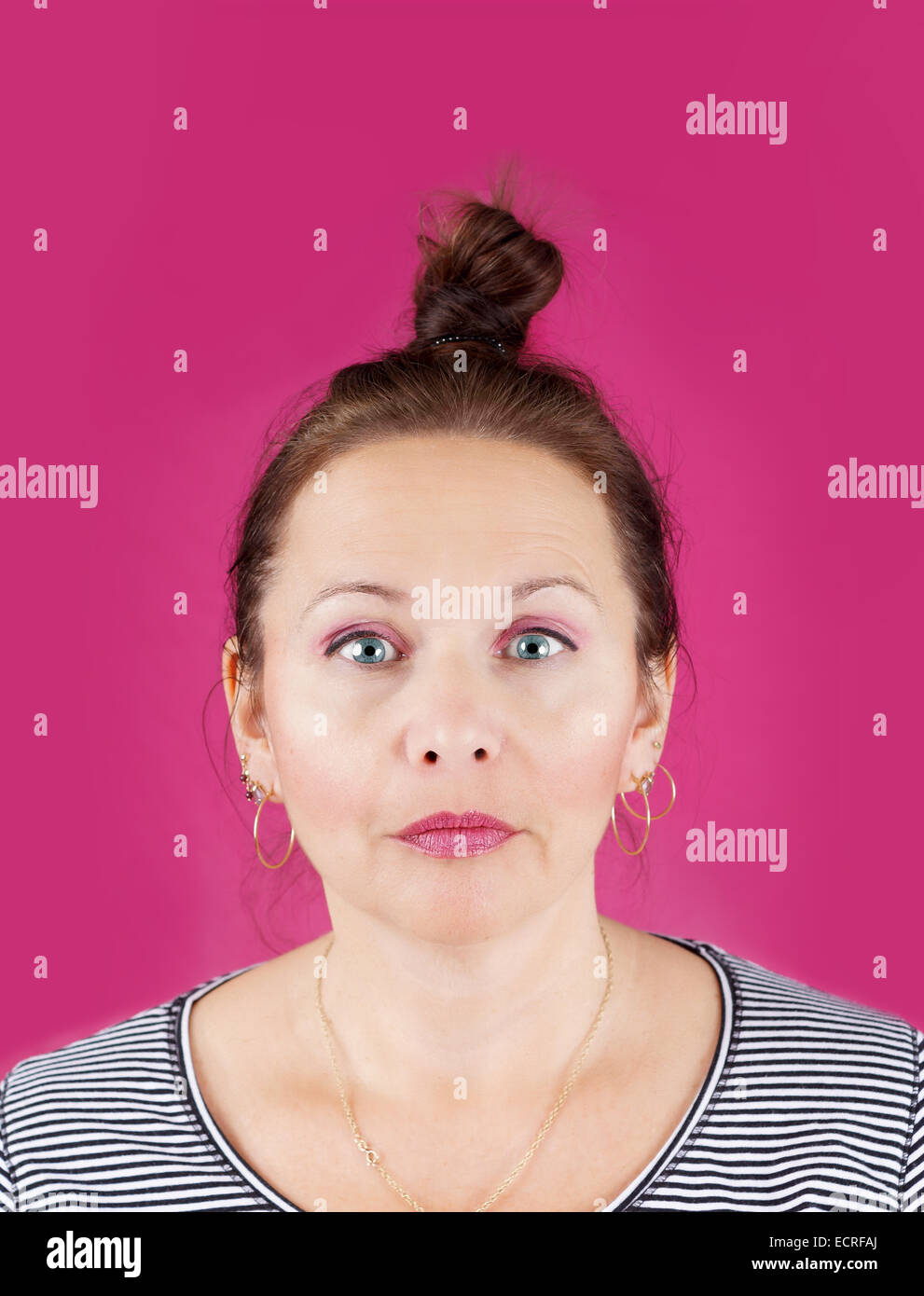 Portrait von neutrales Gesicht mittlere gealterte Frau mit Haar Bun über rosa Hintergrund Stockfoto