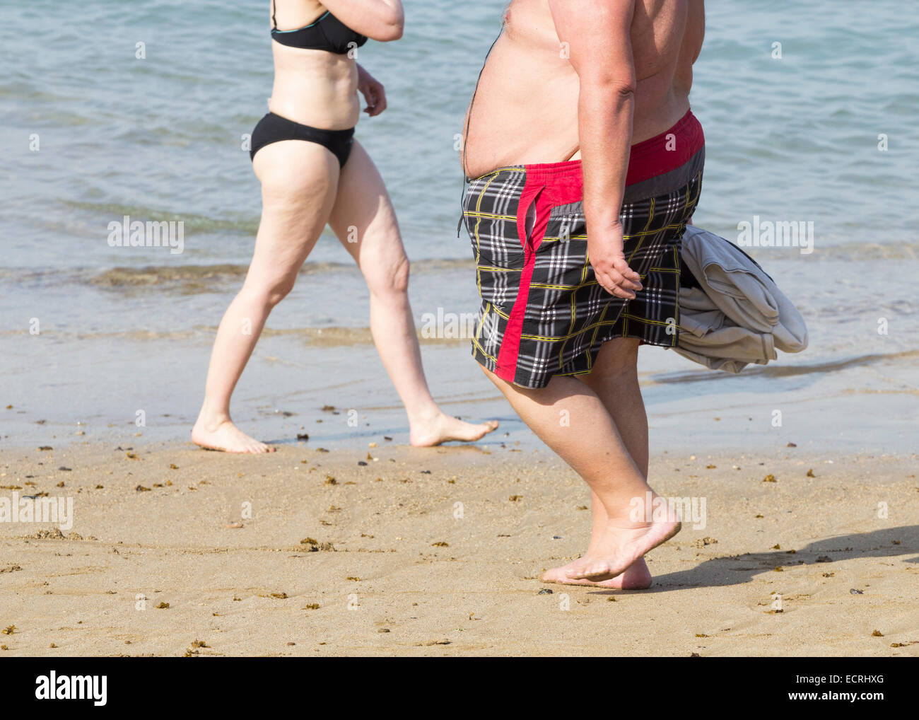 Übergewichtigen Mann zu Fuß am Strand Stockfoto
