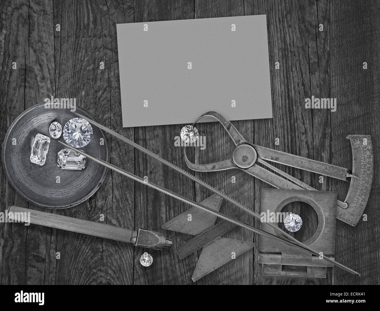 schwarz / weiß Bild einer Vintage Juwelier-Tools und Diamanten über Holzbank, leere Karte für Ihr Unternehmen Stockfoto