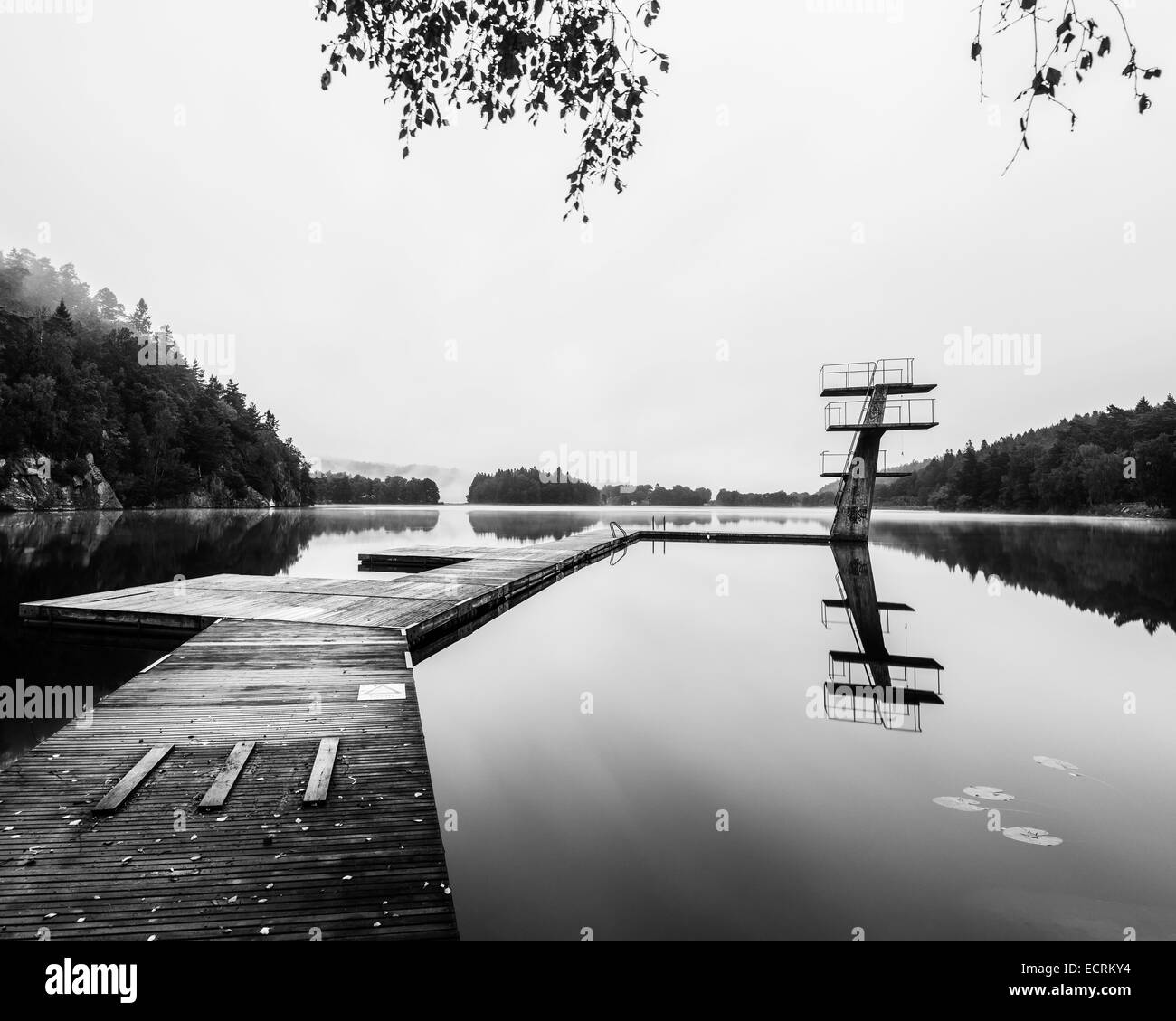 Hölzerne Dock und Sprungbretter auf einem ruhigen See Stockfoto