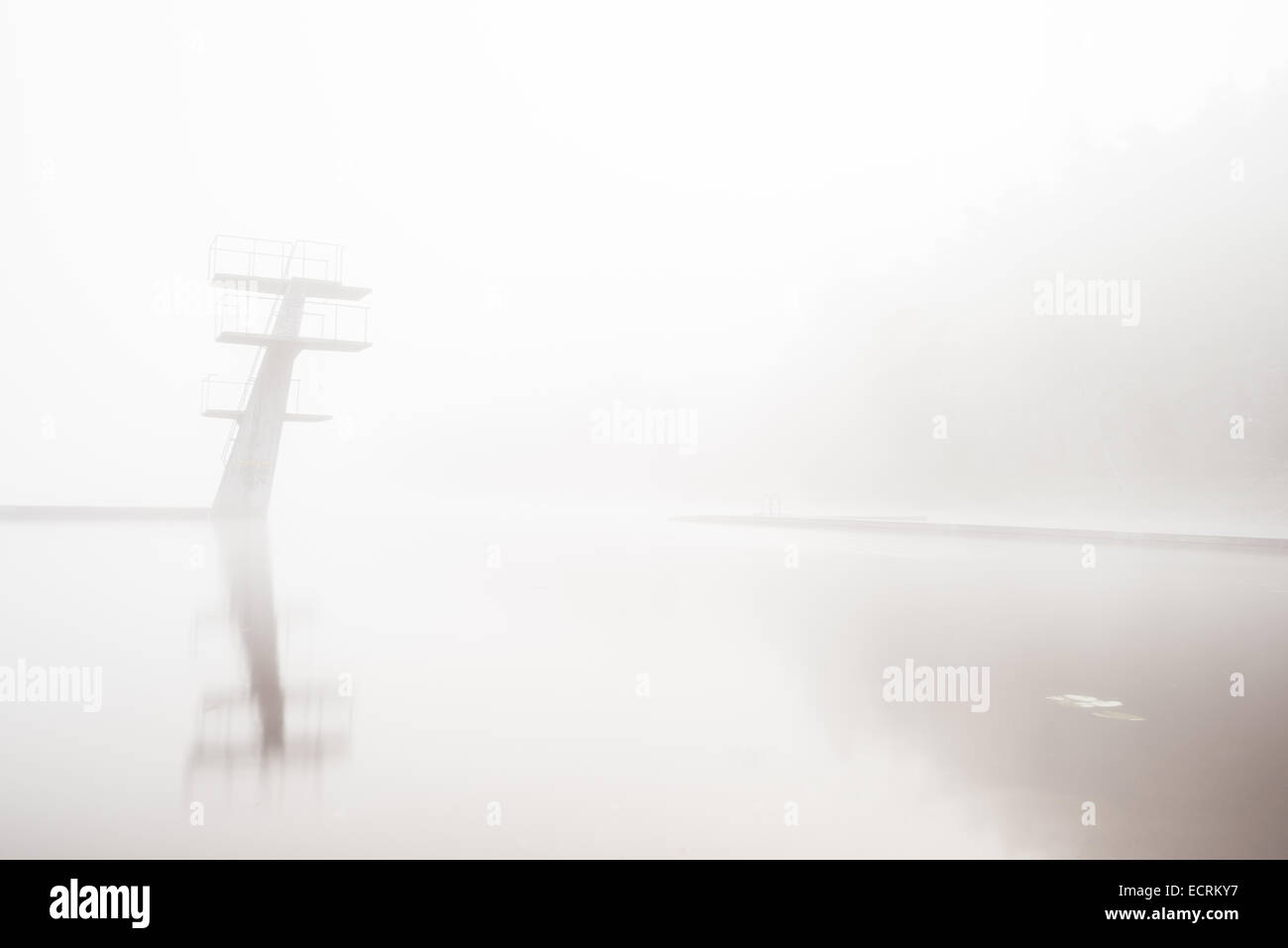 Abgestufte Sprungbretter in einem See in dichtem Nebel Stockfoto