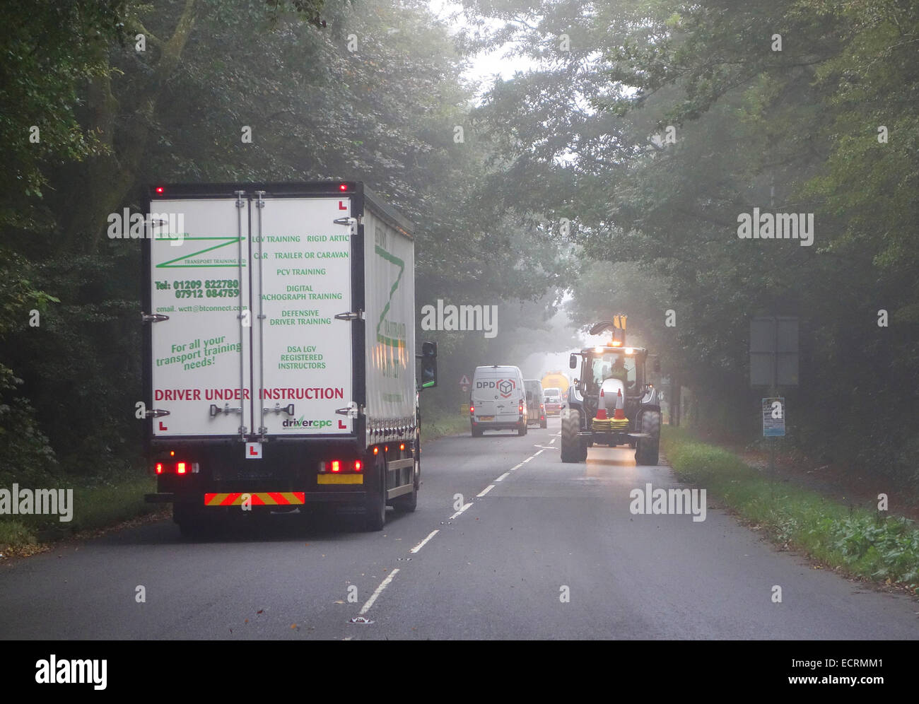 Verkehr fahren in nebligen Wetter auf einer Landstraße in Cornwall, England, uk Stockfoto
