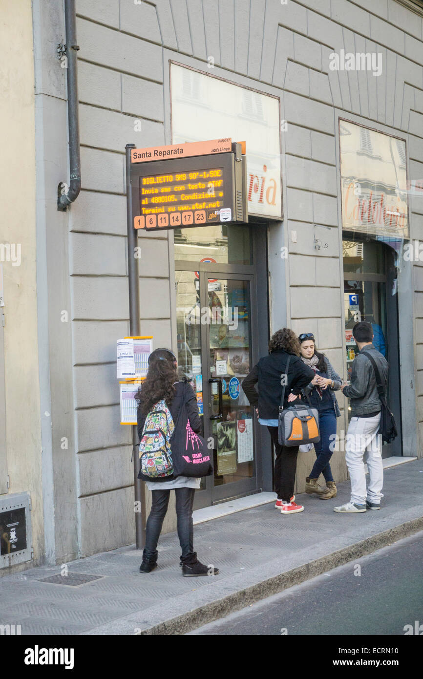 Gruppe von italienischen Jugendlichen warten auf Busse Bus Haltestelle ausgestattet mit elektronischen Leser Bord Bus Informationen Florenz Stockfoto