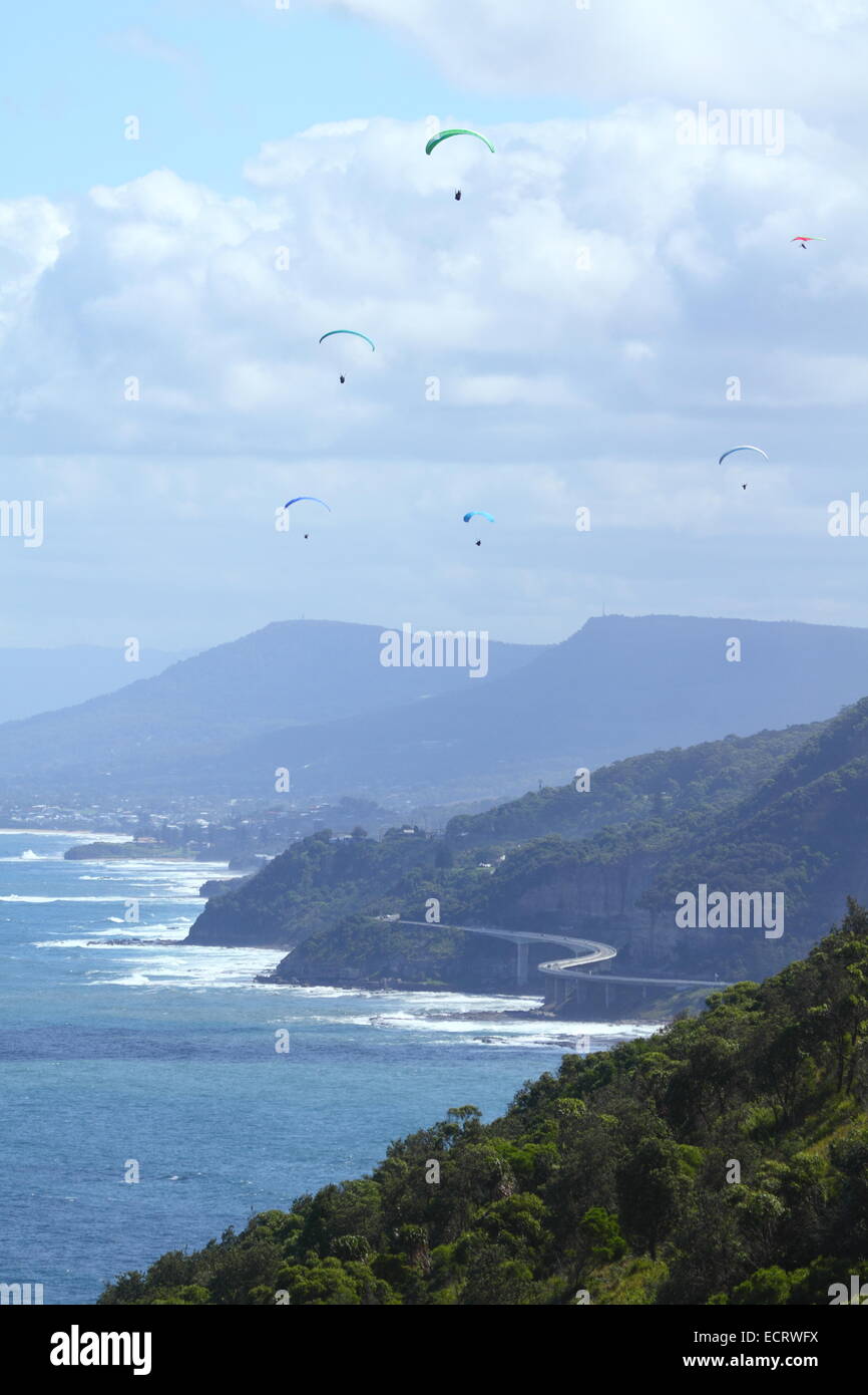 Paragleiter und einem Hängegleiter fliegen Sie über Sea Cliff Bridge auf die Grand Pacific Drive in Clifton, in der Nähe von Sydney, NSW, Australien. Stockfoto