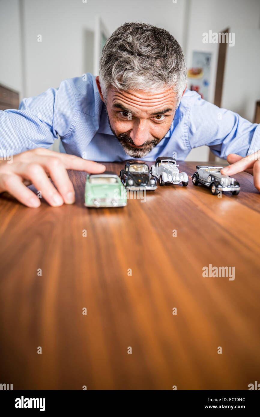 Mann spielt mit Spielzeug-Autos Stockfoto