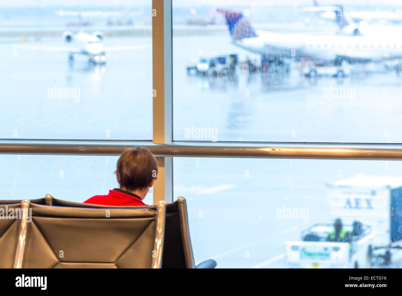 IAH, Houston George Bush Intercontinental Airport, Houston, TX, USA - Kind sitzt vor einem Fenster im Wartebereich des Flughafens Stockfoto