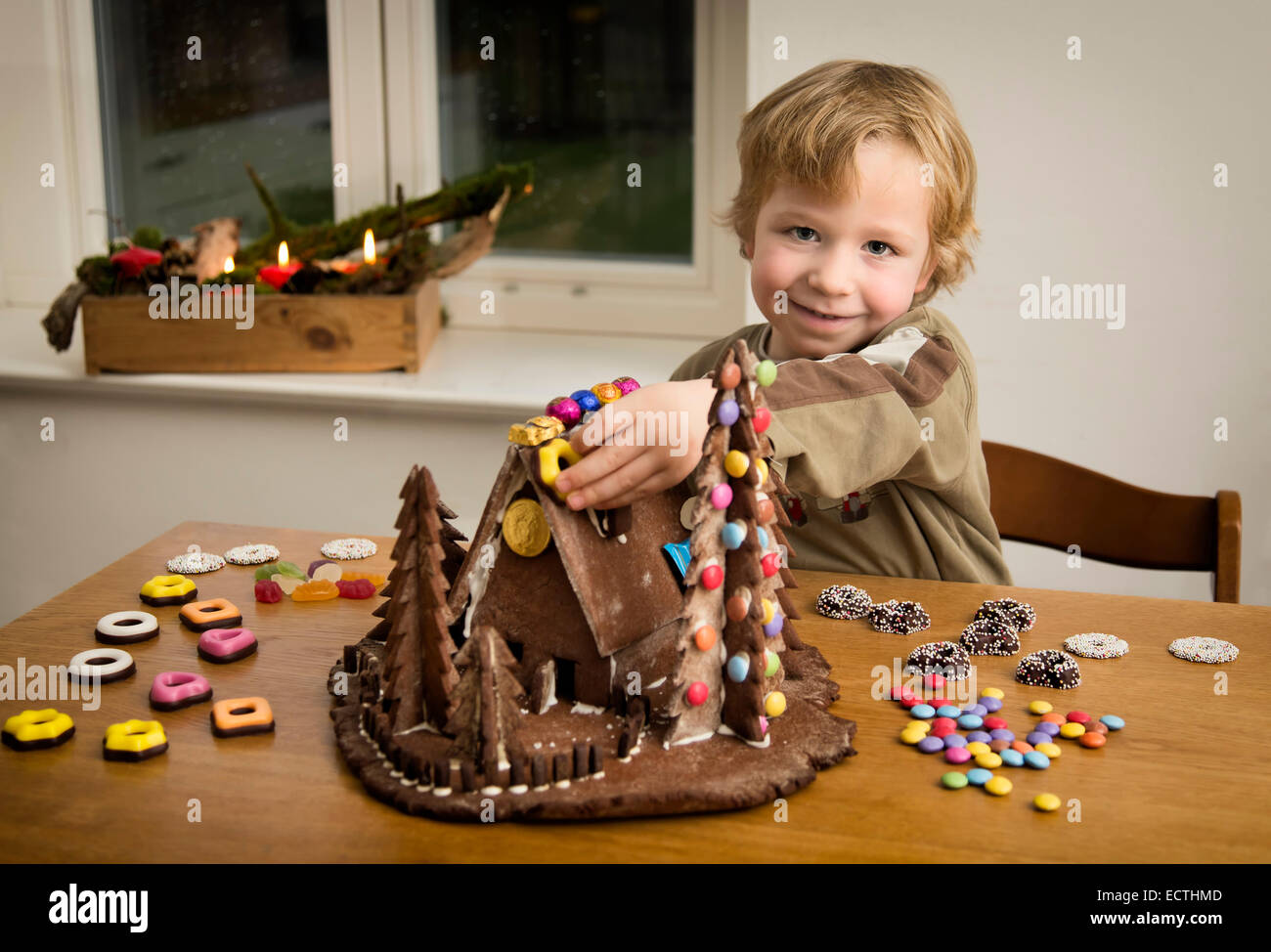 Junge, 4 Jahre, ein Lebkuchenhaus Dekoration Stockfoto