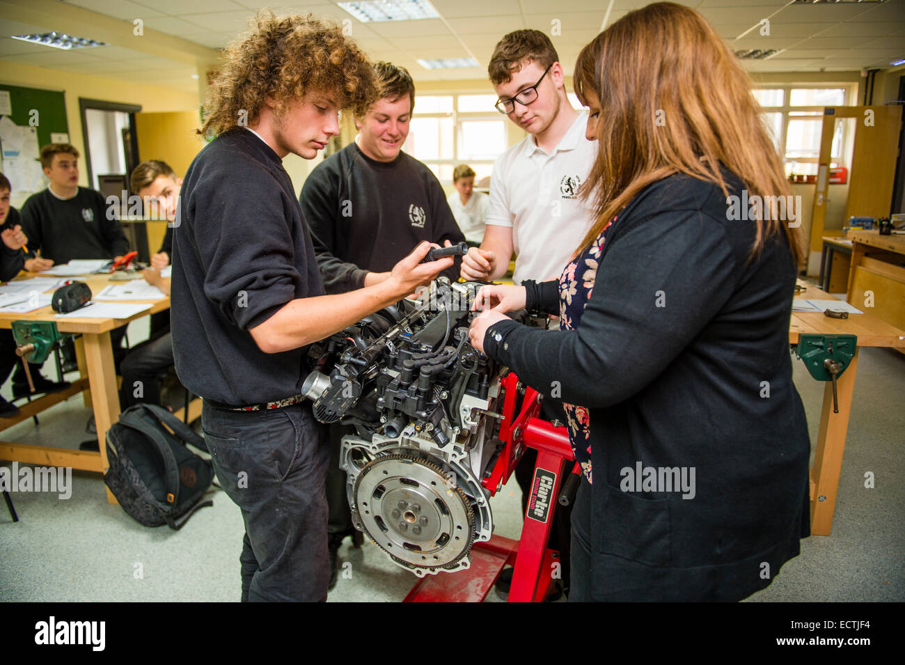 Praktische Berufsausbildung Mittelschule Wales UK: eine Frau Lehrer Unterricht Jahr 12 und 13 6. Form über ein Automotor im Teenageralter in einer Maschinenbau-Klasse-Lektion Stockfoto