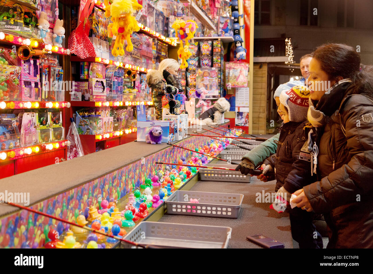Eine Familie, die ein "Haken eine Ente" Spiel in einem Stall, Brügge Weihnachtsmarkt, Brügge, Belgien Stockfoto