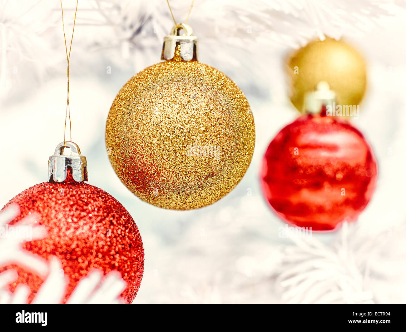 Rote und goldene Kugeln schmückt den weißen Weihnachtsbaum - Jahrgang getönt Stockfoto