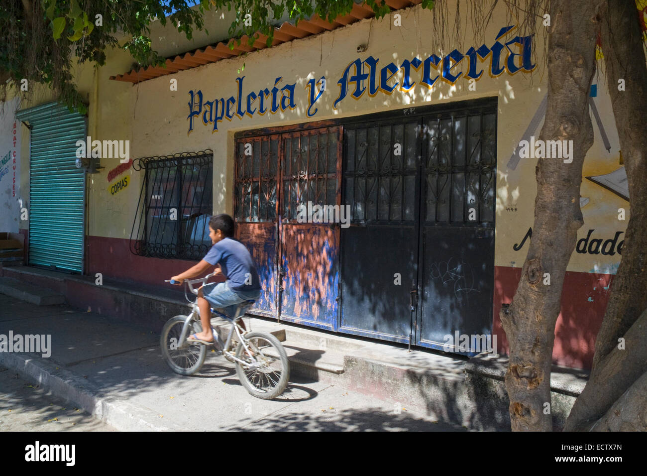 Mexikanische junge mit seinem Fahrrad auf dem Bürgersteig in Bucerias, Bundesstaat Nayarit. Stockfoto