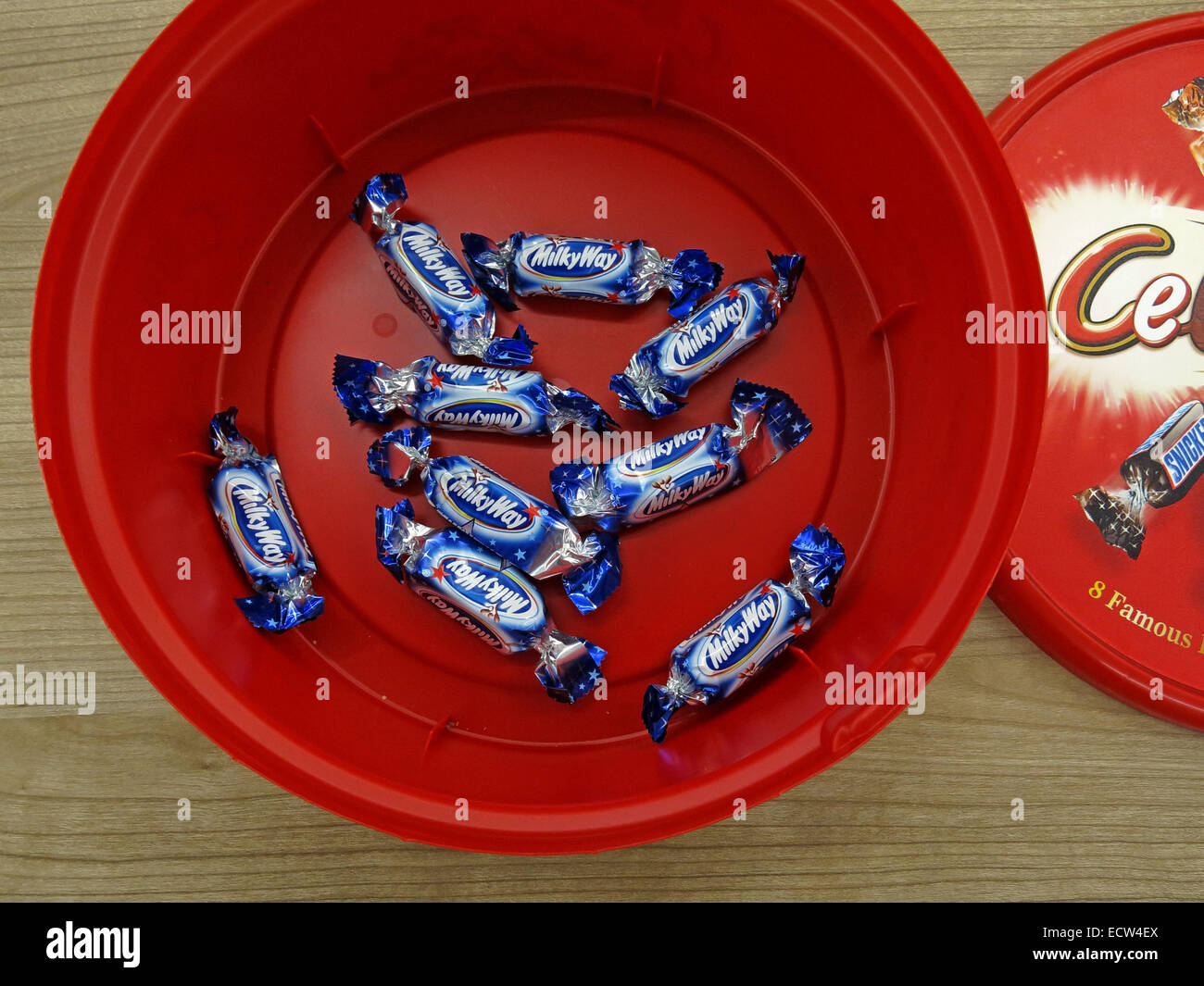 Die letzte unbeliebte Büroschokolade, die Reste einer roten Plastikwanne zur Weihnachtszeit – Milchstraße Stockfoto